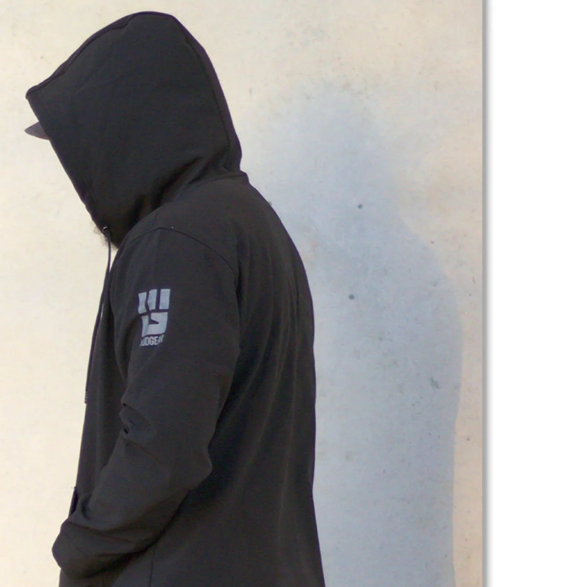 Man wearing the black MudGear Freedom Ops Waterproof Tech Hoodie outdoors